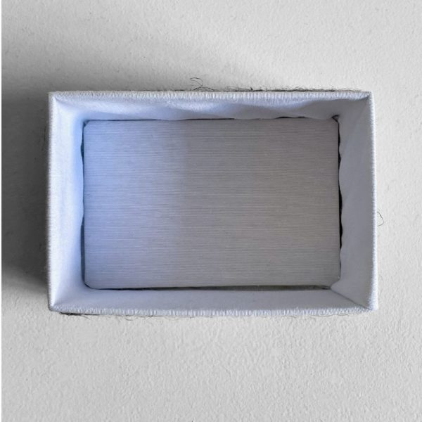 Interior de la caja Soren forrado en tela lisa blanca.