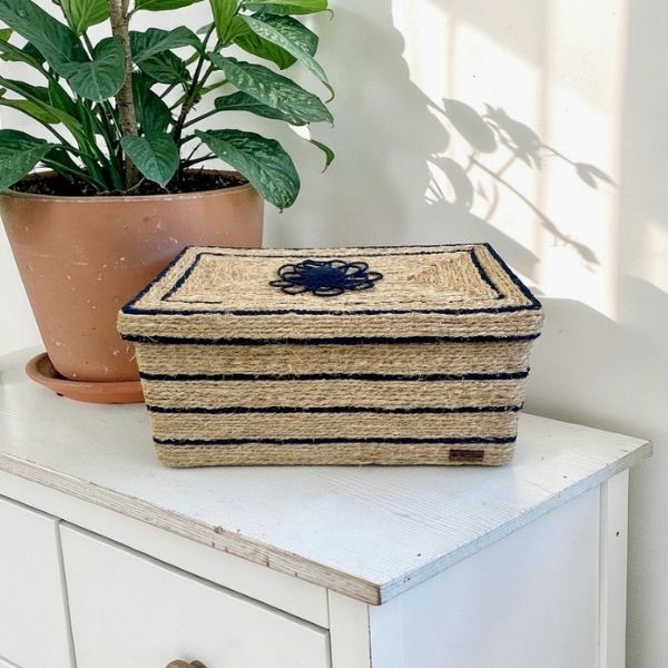Caja decorativa Azura, forrada en cuerda de henequén, con detalles en macramé azul e interior en tela con motivo floral, diseño artesanal.