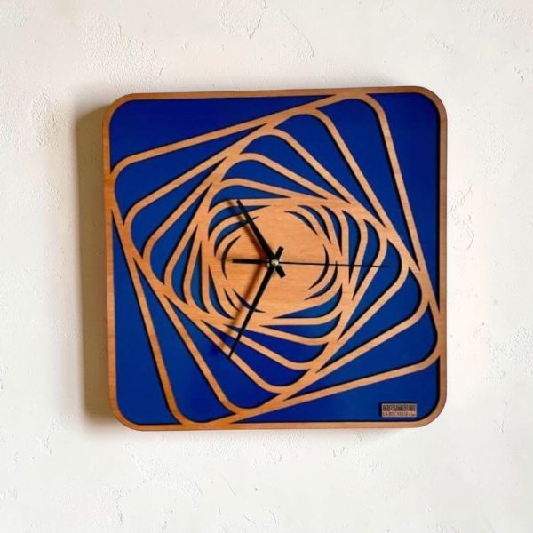 Reloj de pared Cadencia en madera con base azul y diseño geométrico calado, pieza artesanal