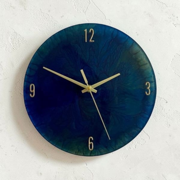 Reloj de pared artesanal Serena en resina epóxica azul con variaciones de tono y sutiles matices dorados